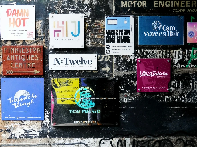 Various signs and posters on a textured wall